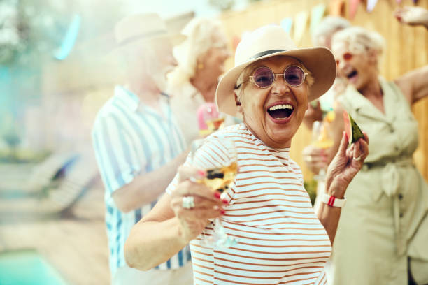 happy senior woman having fun on a pool party with her friends. - active seniors retirement enjoyment swimming pool photos et images de collection