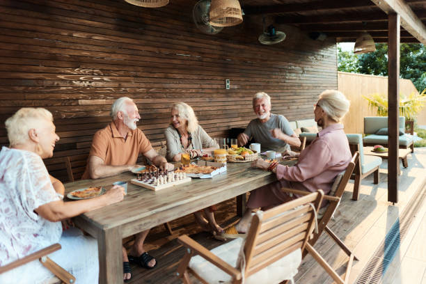 istock Happy seniors talking during social gathering at picnic table in the backyard. 2067975220