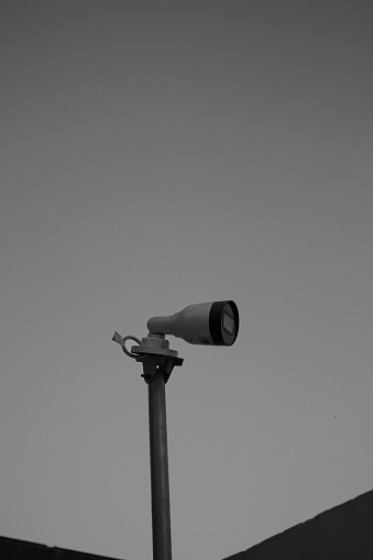 Cctv security camera in a pole on top of a wall