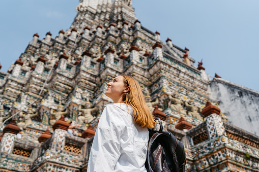 Young woman enjoying the view of Wat Arun (The Temple of Dawn) in Bangkok in Thailand.