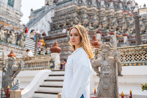 Portrait of a young woman at Wat Arun (The Temple of Dawn) in Bangkok in Thailand.