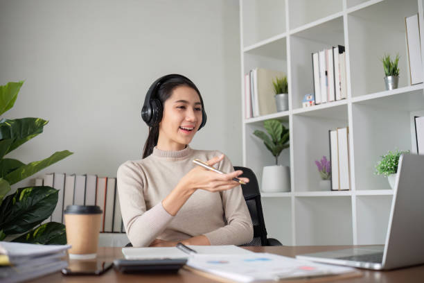 istock Young Asian student studies online about graphs and statistics. Happy Zoom video call studying with laptop computer 2068004525
