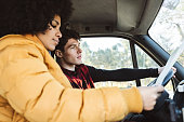 multiracial couple starts their trip route by driving the car on their vacation