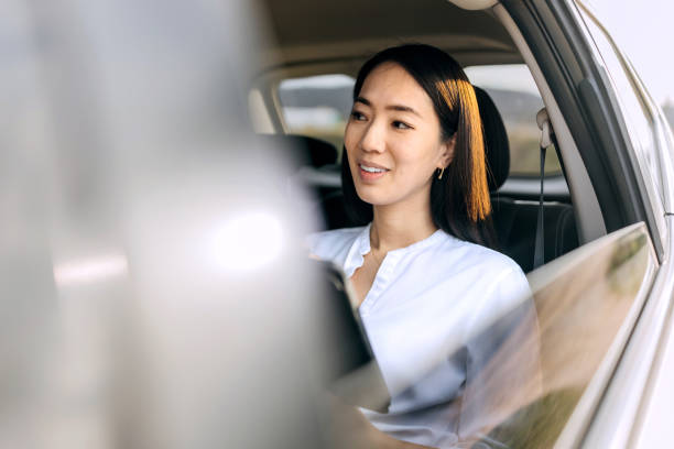 istock Smiling beautiful woman working while sitting on a backseat of car 2068081289