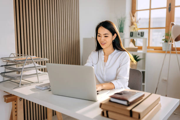 istock Beautiful well dressed woman using laptop at home office 2068085463