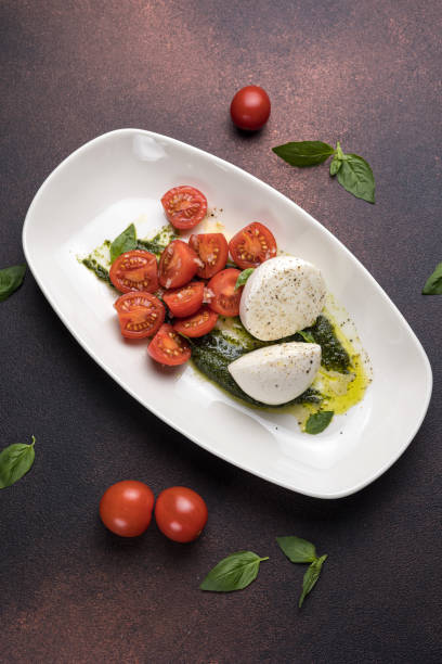 istock Caprese salad with mozzarella cheese, cherry tomatoes and basil 2068093346