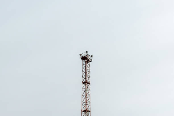 Old huge spot light lamp system on a overcast sky background. Aged metal tower frame construction with powerful lamps to illuminate big object.Copy space.
