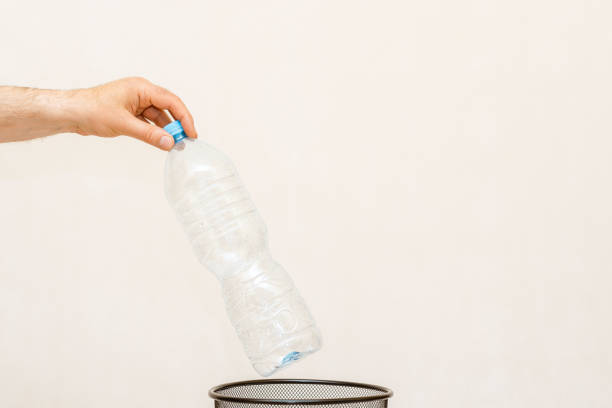 istock The plastic bottle is thrown into the trash basket for disposal and recycling.White,gray background,selective focus,copy space. 2068104321
