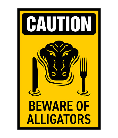 Caution - Beware of Alligators or Crocodiles sign for areas forbidden for swimming. Hungry reptile considers you as a food source and prepares a knife and a fork