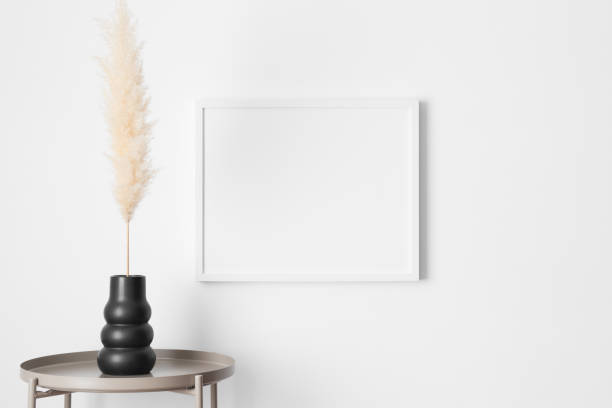 istock White frame mockup on the wall with a pampas decoration. 2068128032