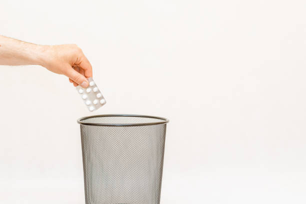 the medicine is thrown away into the basket trash,for disposal and recycling.white,gray background,selective focus,copy space. - 11313 - fotografias e filmes do acervo