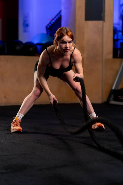 istock in a sports club red-haired trainer bends over and does an exercise with ropes 2068137008