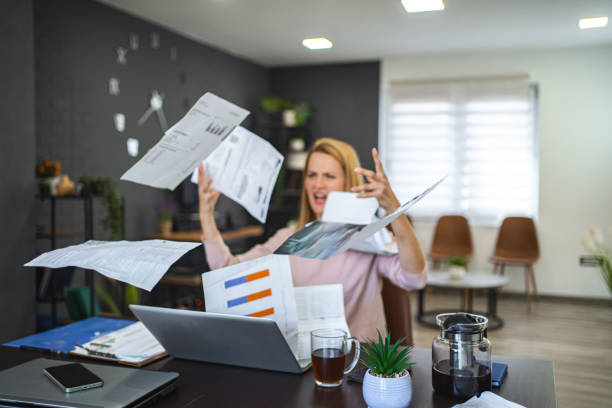 istock Stressed blonde woman throwing paperwork in air 2068153799