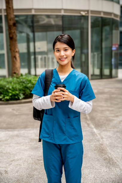 istock Portrait of smiling nurse drinking coffee while standing outdoors. 2068157018