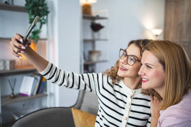 istock Two female friends taking selfies with mobile phone 2068159161