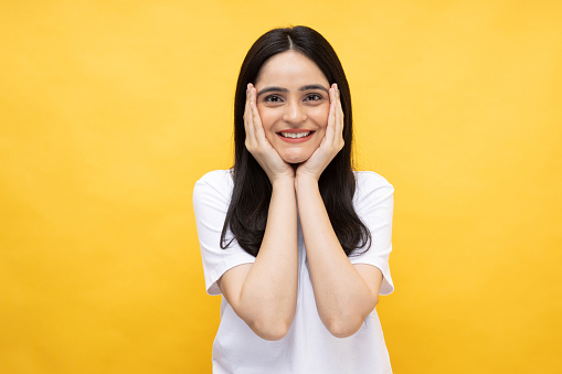 Portrait of young girl wearing white t-shirt on yellow background