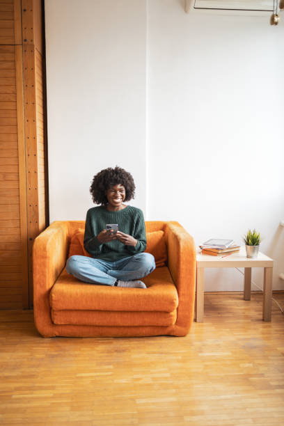 istock Happy woman sitting at home and using mobile phone 2068195643