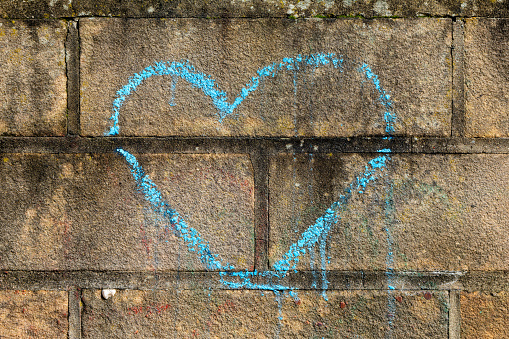 a heart is painted on a brick wall with blue chalk