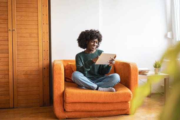 istock Beautiful woman sitting at home and use digital tablet 2068196723