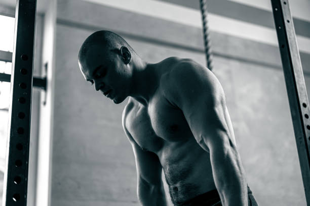 A strong male sportsman engages in fitness wheel pulls outside, demonstrating his dedication to physical fitness. gym Training Session Man Showcases Wheel Pull Outdoors