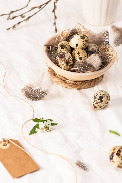 istock Quail eggs in a ceramic bowl decorated with feather. Organic food. Rustic style. Easter background with label 2068217044