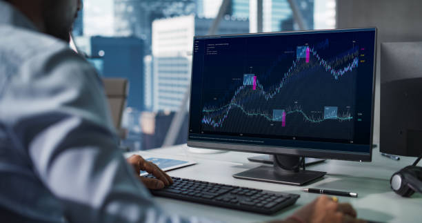istock Hedge Fund Office: Indian Financial Analyst Using Computer with Display Showing Real-Time Stocks, Exchange Market Charts. Hard Working South Asian Trader Making Profitable Trade. 2068229117