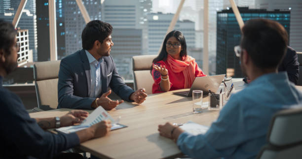 istock Indian Female Project Manager Makes a Business Presentation for a Diverse Creative Team in a Meeting Room in an Agency. South Asian Colleagues Gathered Around a Conference Table. 2068231721