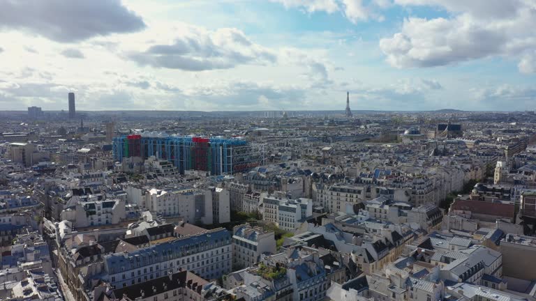 Aerial Shot of Paris Cityscape with Eiffel Tower, Montparnasse Tower in Background, and Centre Georges Pompidou in Foreground