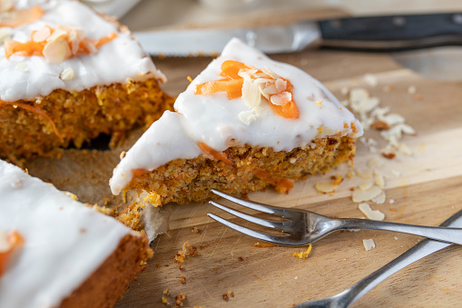 Piece of homemade carrot cake with almonds and lemon sugar glaze