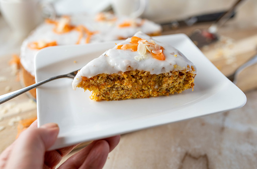 Delicious slice of homemade carrot cake with almonds and sugar glaze  for easter holiday.
