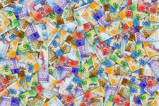 Large numbers of swiss banknotes currency lying flat on the table