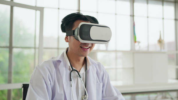 istock Happy young asian male doctor in uniform wearing VR headset and virtual interface. Future medicine and modern technologies gadgets in healthcare concept 2068394600