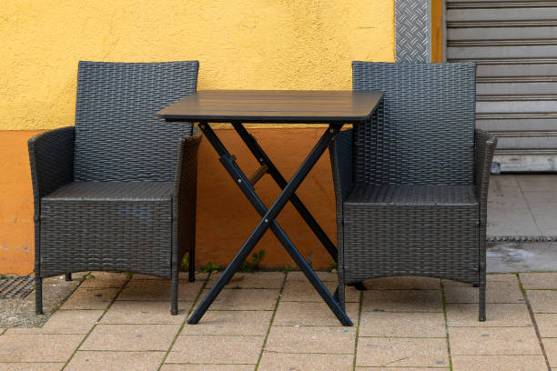 istock chairs with table in front of an orange house wall 2068410119