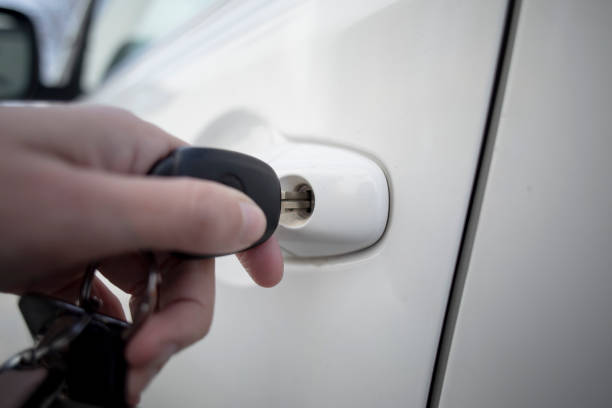 Woman's hand unlocking car door with key