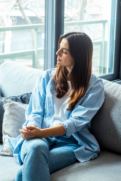 istock Exhausted frustrated young woman touching forehead, sitting on couch alone, suffering from strong headache or migraine, worried girl thinking about problems, divorce or break up, lost in thoughts 2068435443