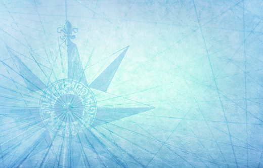 A compass and intersecting navigational lines on a light blue background.