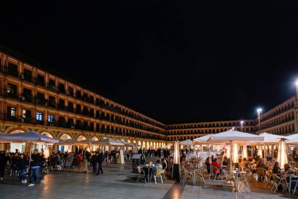 Many people are relaxing at the outdoor tables in Plaza de la Corredera, one of the most emblematic places in Cordoba. The large quadrangular square was built in 1683, and takes its name after the bullfights that were held in this space.
