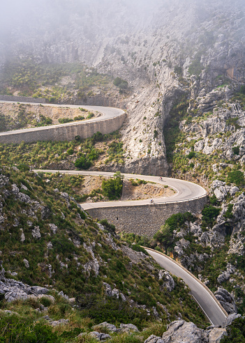 The famous Sa Calobra road in Mallorca, Spain, a favorite place for all cyclists. Lonely cyclists climb a winding road