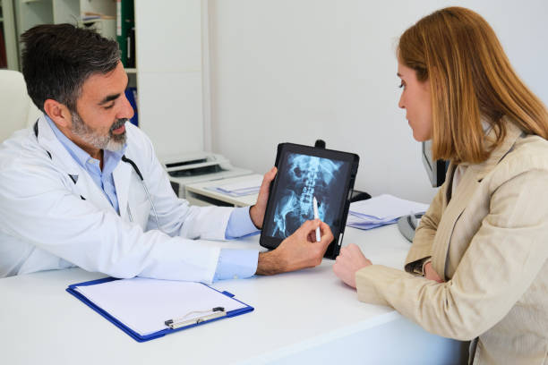 istock Doctor explaining x-ray to his female patient after surgery for a broken hip. 2068518803