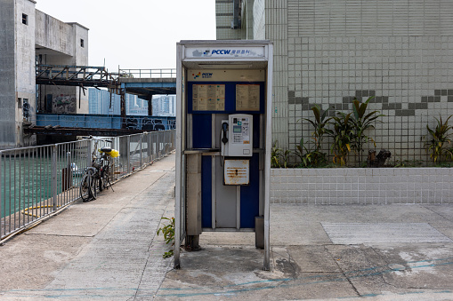 Hong Kong - March 8, 2024 : PCCW telephone booth in Kowloon, Hong Kong.