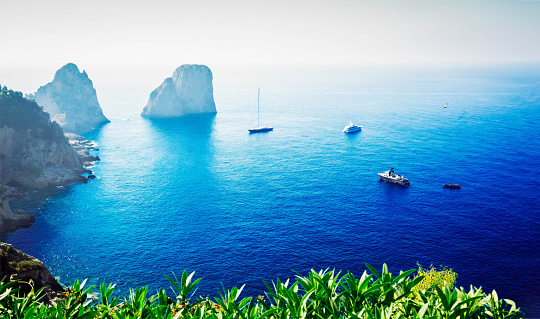 Famous Faraglioni cliffs and Tyrrhenian Sea blue water, famous Capri island, Italy, retro toned