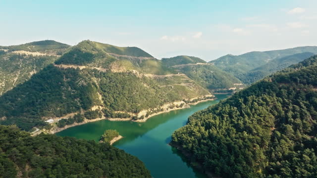 Drone point of view of dam lake between the forest mountains