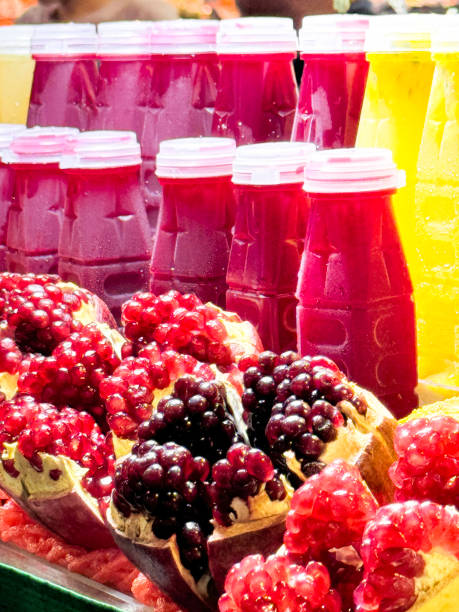 Stock photo showing close-up view of shelf of freshly squeezed fruit juices and pieces of fruit being kept chilled.