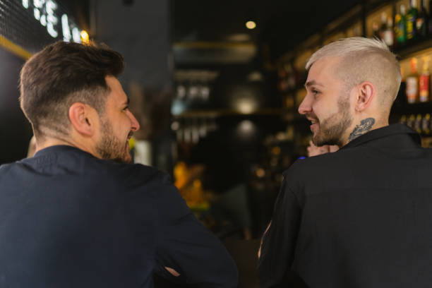 istock Male buddies engage in conversation relaxing at bar in evening 2068588075