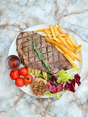 Stock photo showing a freshly cooked griddled sirloin steak with criss-cross diamond griddle lines adding a pattern to the surface of this medium rare beef steak.