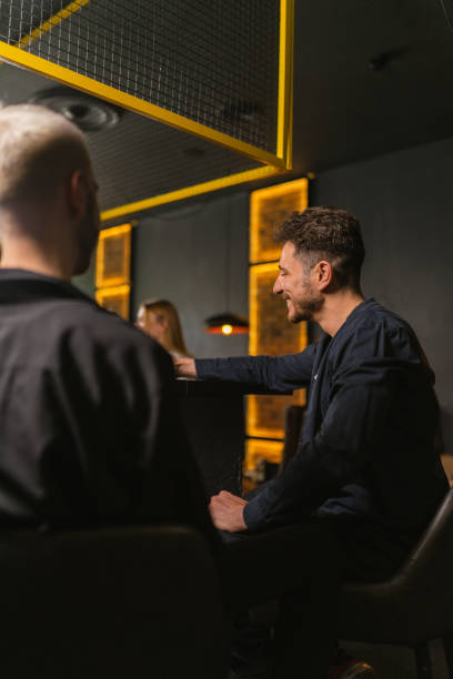 istock Gentlemen engage in conversation standing near bar counter 2068596468