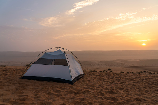 One small tent in Wahiba desert in Oman at sunset.