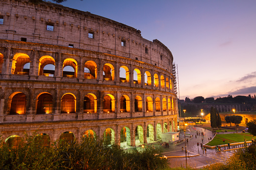 view of Colosseum illuminated at night in Rome, Italy