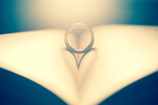 Wedding ring on the pages of a book in a heart shape