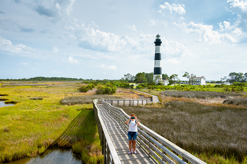 Woman taking a photo at Bodie Island Lighthouse